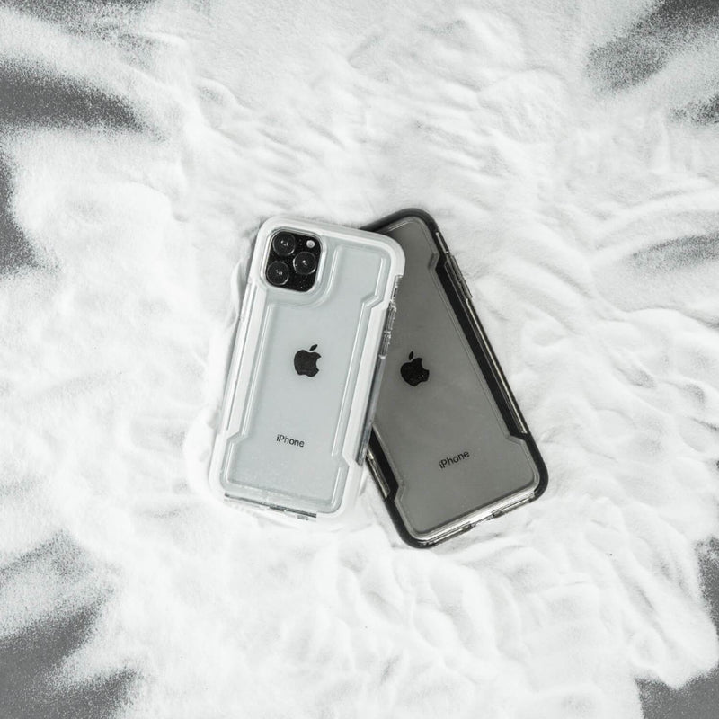 Two Raptic iPhone 11 Pro Max cases - CLEAR sitting on top of a pile of snow.