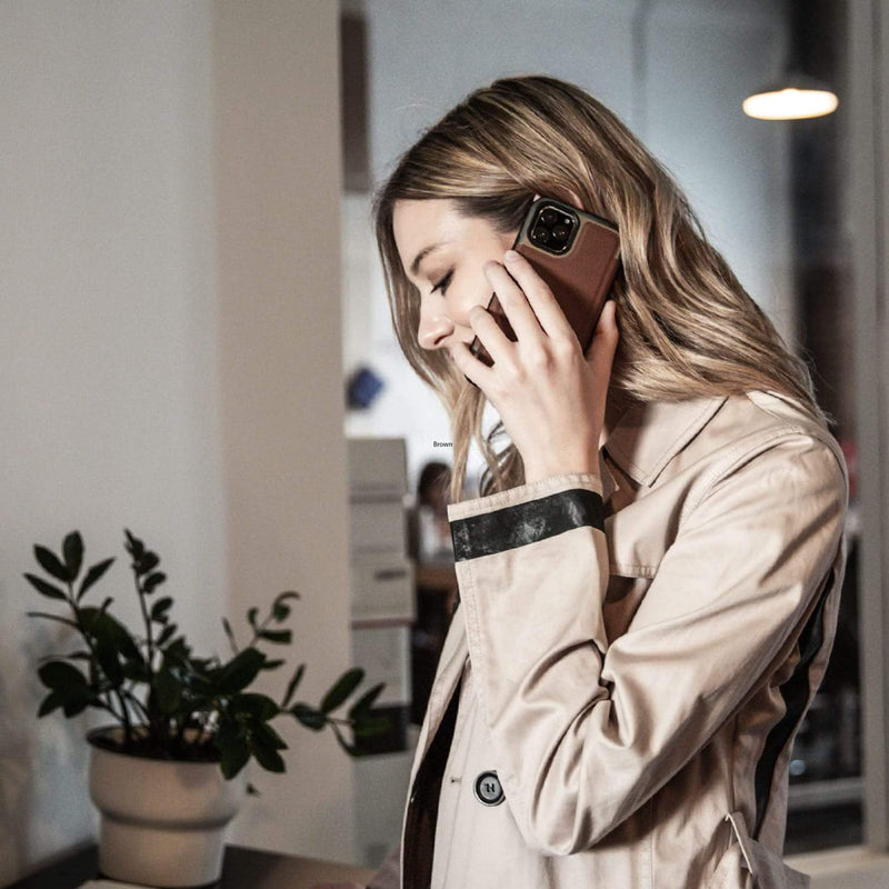 A woman in a protective trench coat talking on her Raptic iPhone 11 Pro Case - Prime.