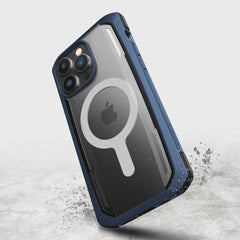 The Raptic iPhone 14 Pro Max Case ~ Secure, in rugged blue, offers military-grade drop protection and a transparent back with a circular design that showcases the Apple logo as it hovers above a textured surface.