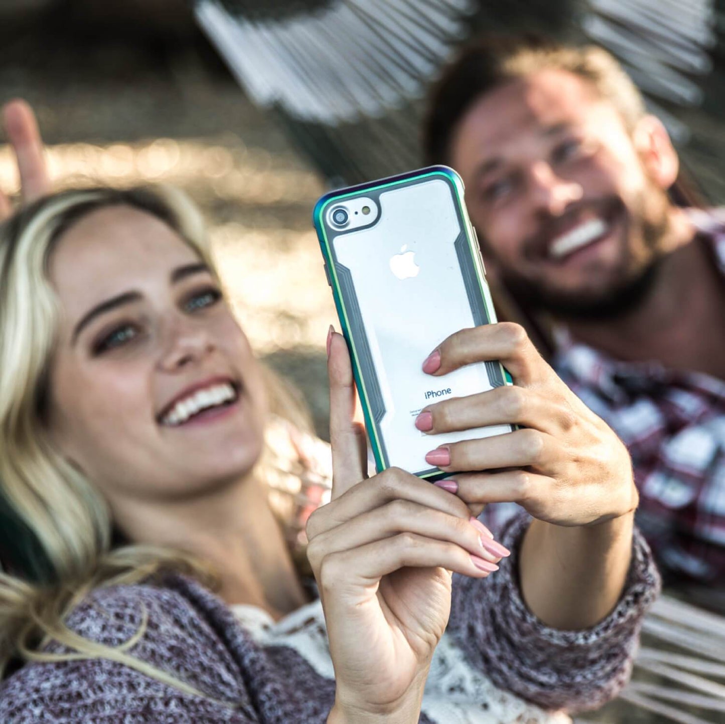 A man and woman taking a selfie in a Raptic iPhone SE/8/7 Case - SHIELD hammock.