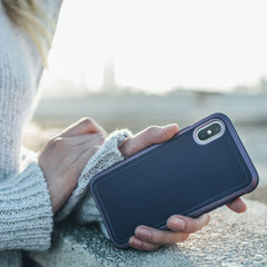 A woman holding an iPhone XR protected by the Raptic ULTRA case.
