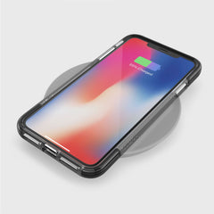 A smartphone with a clear Raptic iPhone XS Max case is on a wireless charger. The screen shows a 55% charged battery icon, and the military-grade drop protection keeps it safe.