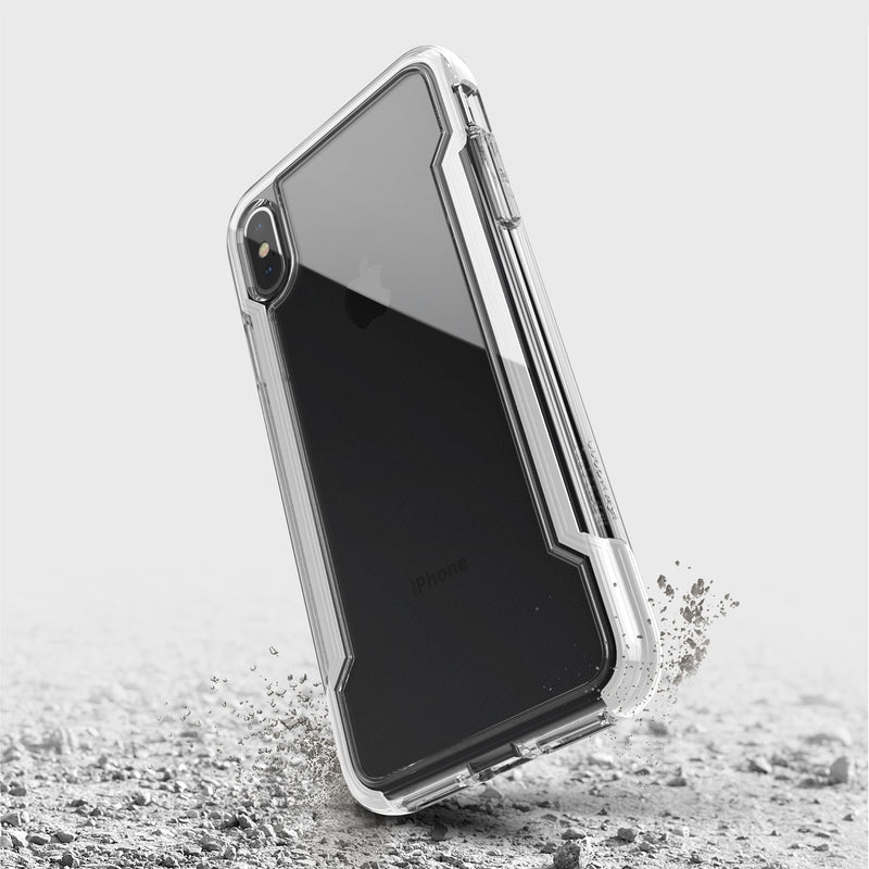 The Raptic iPhone XS Max Case - CLEAR, featuring transparent, anti-yellow, and anti-scratch protection, appears suspended above a cracked surface to demonstrate its military-grade drop protection.