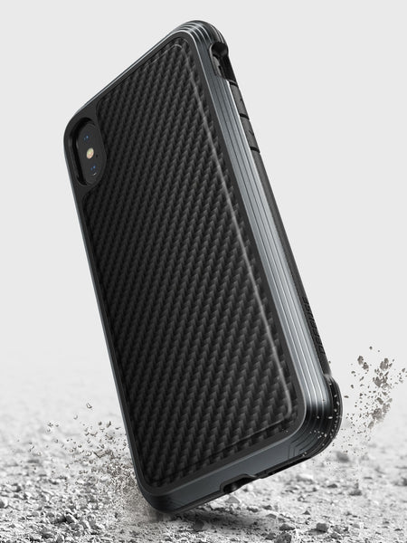 The iPhone XS Max Case - LUX by Raptic is shown on a gray background. This black protective case features a rugged, impact-resistant polycarbonate design with a textured surface.