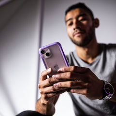 A man is holding a Raptic eco-friendly iPhone 13 Case - TERRAIN.