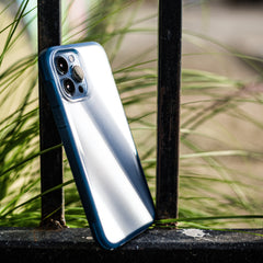 A blue iPhone 13 Pro Max Case - TERRAIN, a Raptic device, is sitting on a fence.